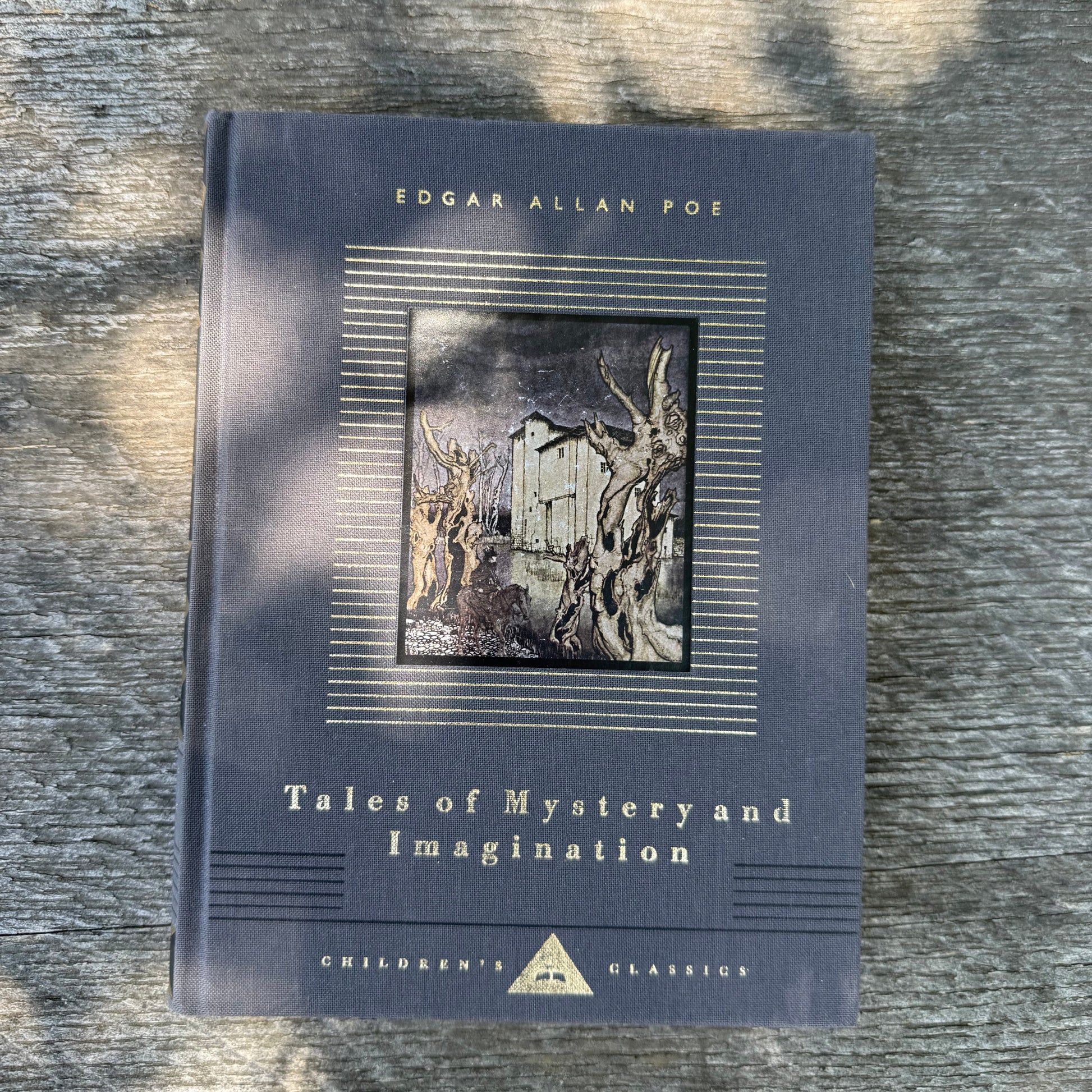 Book titled 'Tales of Mystery and Imagination' by Edgar Allan Poe on a textured surface